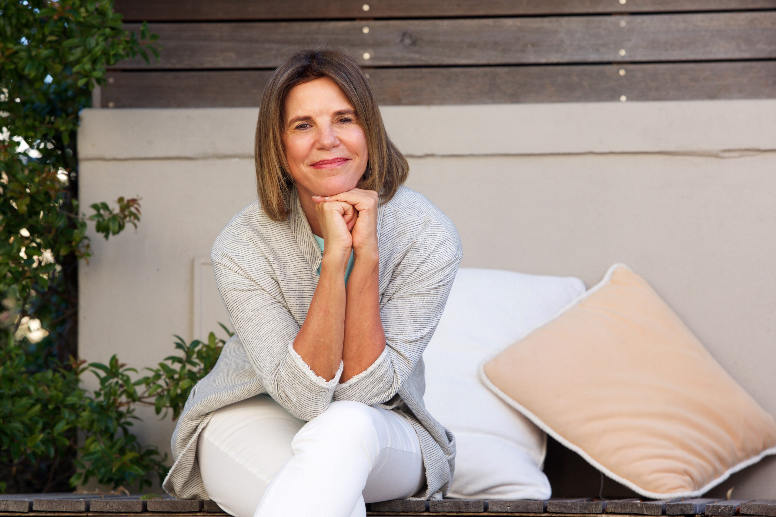 middle age woman smiling and holding his head with two arms