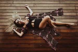 woman lying a wooden floor wearing a swimming suit